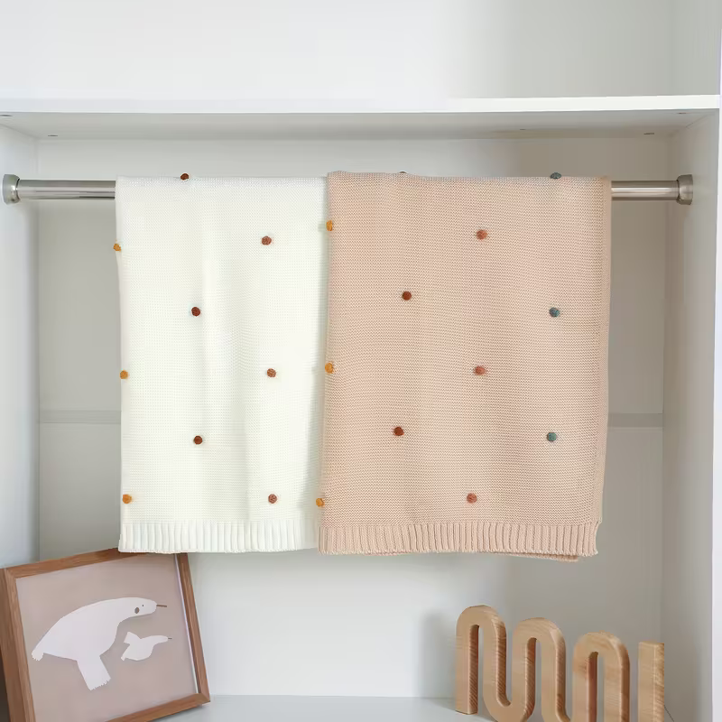strickdecke-babybaumwolle-babydecke-mitpompons